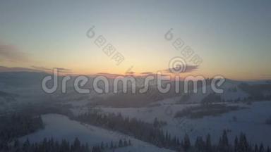 日出时空中北欧冬季景观飞越雪山森林。 冬季无人驾驶飞机飞越山区